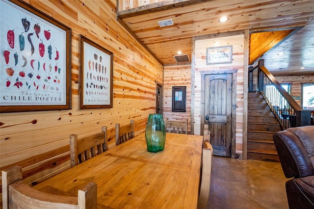 dining room featuring wood ceiling and wood walls