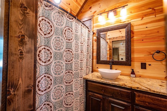 bathroom featuring vanity, vaulted ceiling, wooden ceiling, and wood walls