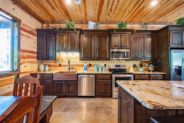 kitchen with wood walls, sink, wood ceiling, stainless steel appliances, and dark brown cabinets