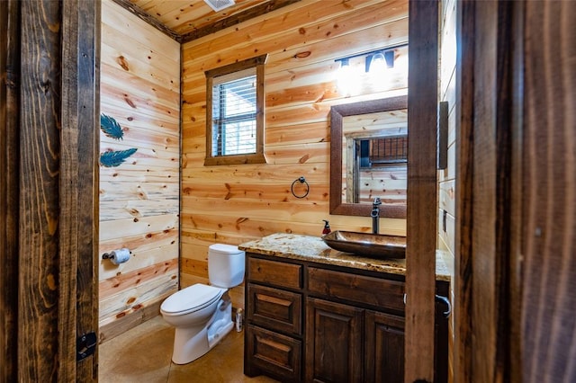 bathroom featuring toilet, wood walls, wood ceiling, vanity, and tile patterned flooring