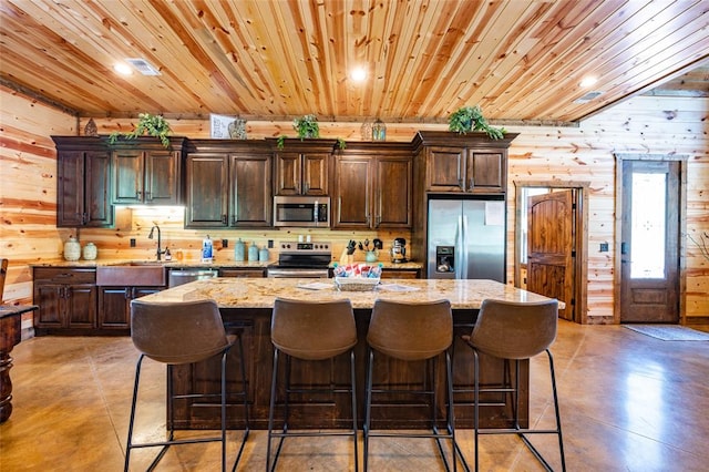 kitchen featuring dark brown cabinets, a center island, and appliances with stainless steel finishes