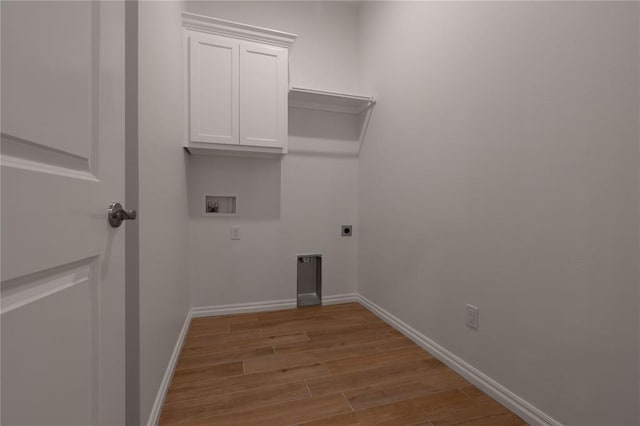 laundry room with cabinets, hookup for a washing machine, light hardwood / wood-style floors, and electric dryer hookup