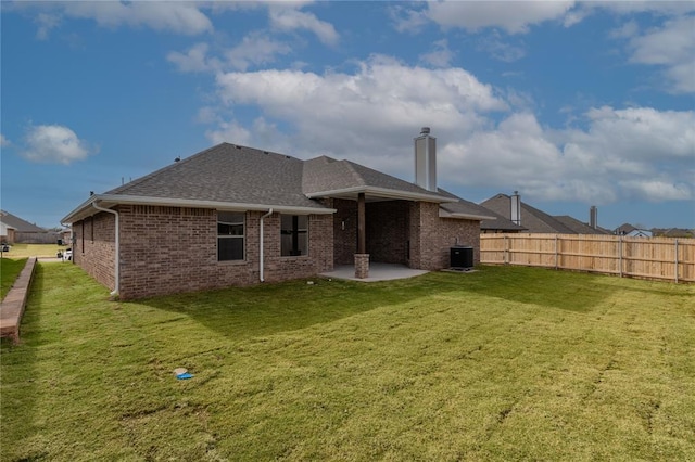 rear view of property with a yard, a patio area, and central air condition unit