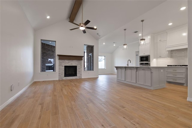 kitchen with light hardwood / wood-style flooring, a kitchen island with sink, and built in microwave