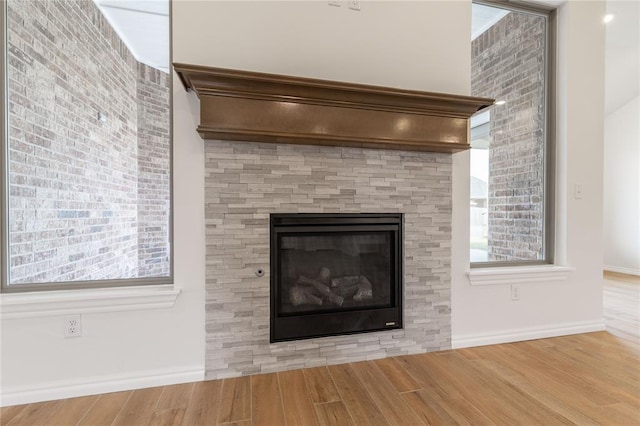 details featuring wood-type flooring and a tiled fireplace