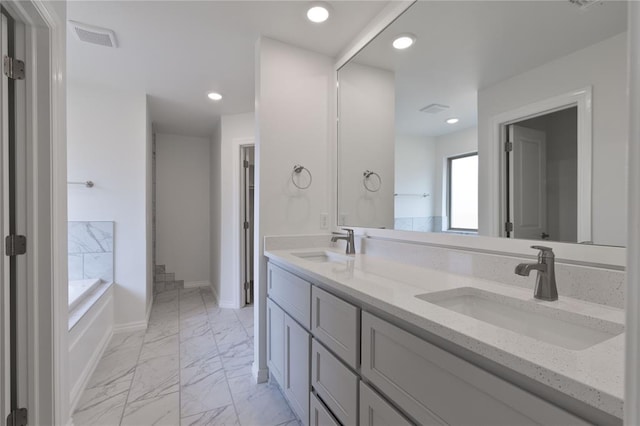 bathroom with vanity and a tub