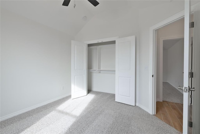 unfurnished bedroom with ceiling fan, light colored carpet, lofted ceiling, and a closet