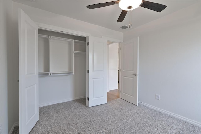 unfurnished bedroom featuring light carpet, a closet, and ceiling fan