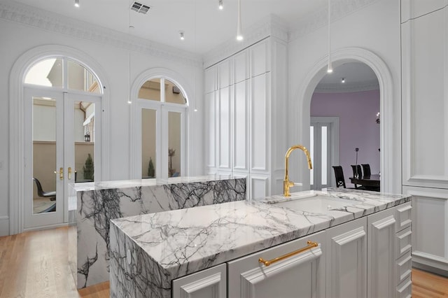 interior space featuring light stone countertops, sink, and light hardwood / wood-style floors