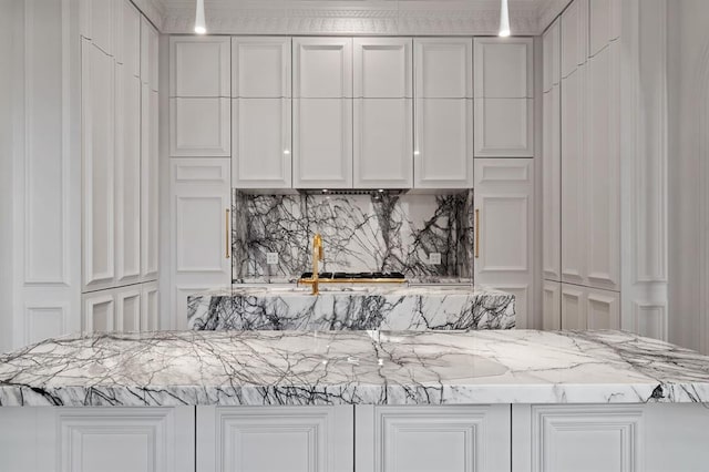 kitchen featuring decorative backsplash, white cabinetry, and light stone countertops