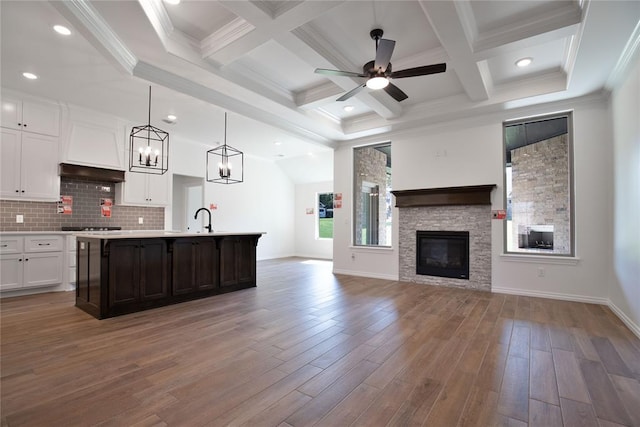 8800 Tyrion Dr, Edmond, OK 73007 - kitchen with open floor plan, light countertops, white cabinets, an island with sink, and a fireplace
