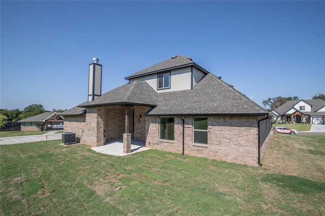 8800 Tyrion Dr, Edmond, OK 73007 - back of property with a yard, a patio area, and a chimney