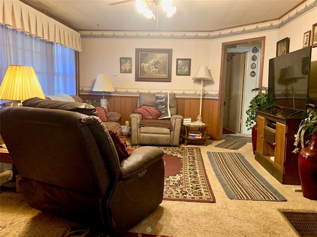 living room featuring ceiling fan, carpet floors, and wooden walls