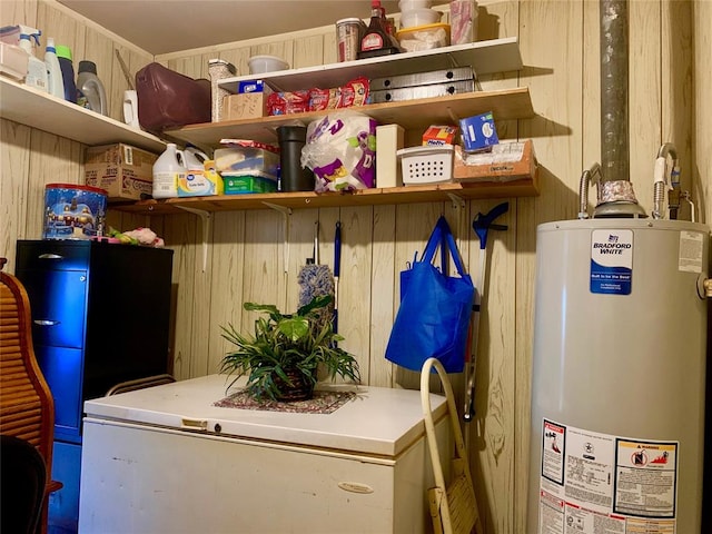 interior space with wood walls and gas water heater