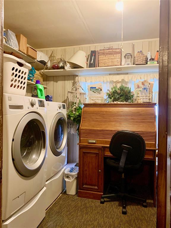 washroom with washing machine and clothes dryer and dark colored carpet