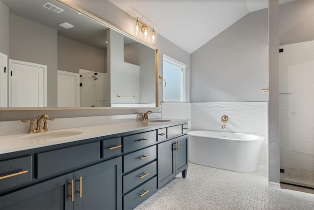 bathroom featuring vanity, shower with separate bathtub, tile walls, and vaulted ceiling