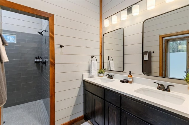 bathroom featuring a tile shower, vanity, and wooden walls