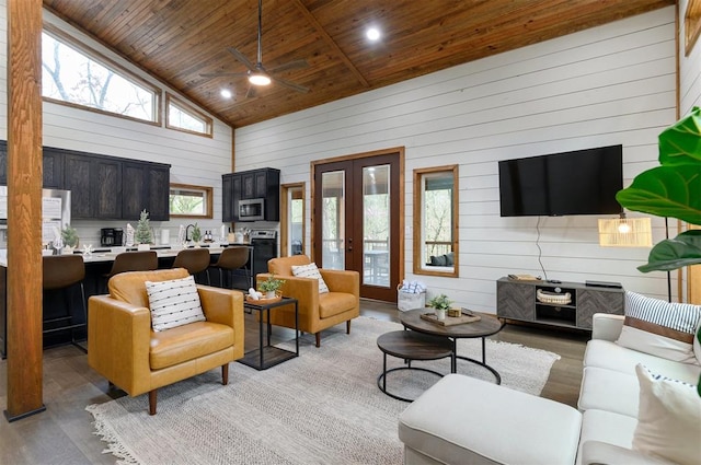 living room with french doors, wooden ceiling, high vaulted ceiling, wood walls, and light hardwood / wood-style floors