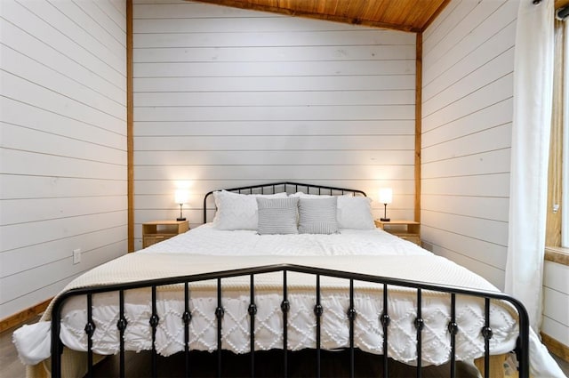 bedroom featuring wooden walls, wooden ceiling, and lofted ceiling