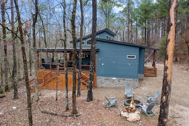 exterior space featuring an outdoor fire pit and a wooden deck