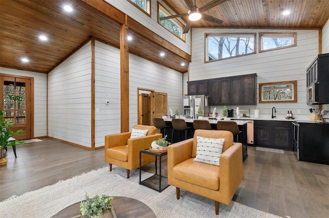 living room featuring plenty of natural light, light hardwood / wood-style floors, and wooden walls