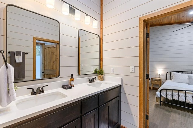 bathroom featuring vanity, hardwood / wood-style flooring, and wooden walls