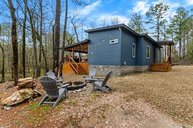 view of side of property with a fire pit and a wooden deck