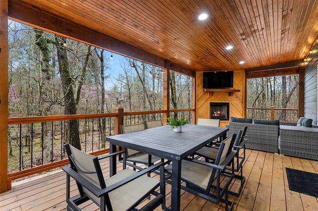 deck with an outdoor living space with a fireplace