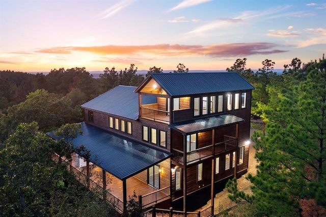 back house at dusk with a balcony