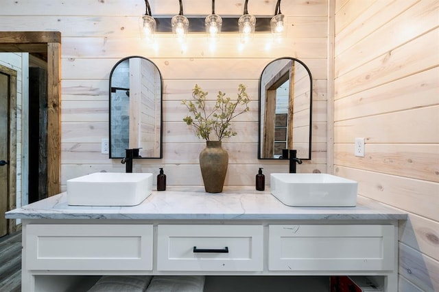 bathroom featuring vanity and wooden walls