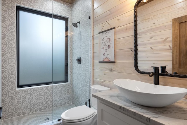 bathroom with vanity, toilet, a shower, and wooden walls