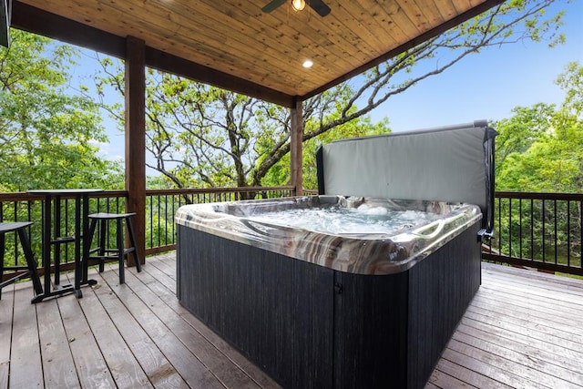 wooden deck with ceiling fan and a hot tub