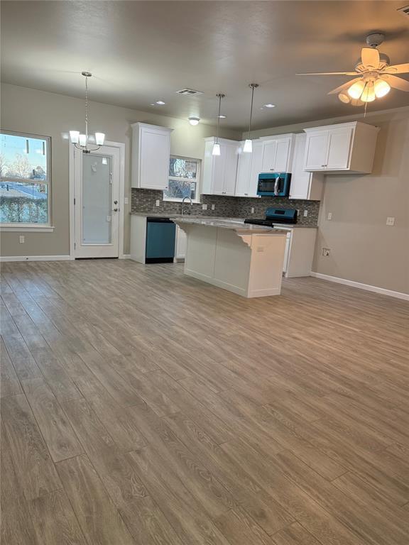 kitchen featuring white cabinetry, a center island, electric range, and decorative light fixtures