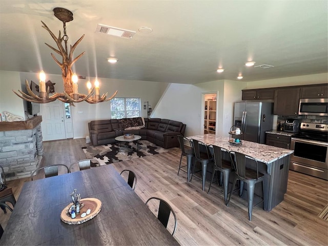 dining room with light hardwood / wood-style floors and a notable chandelier