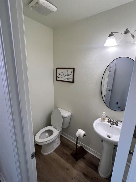 bathroom with hardwood / wood-style floors and toilet