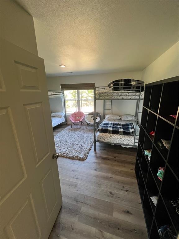 bedroom featuring wood-type flooring and a textured ceiling