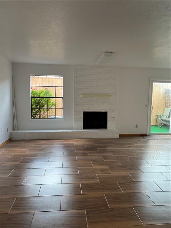 unfurnished living room with a fireplace and a textured ceiling