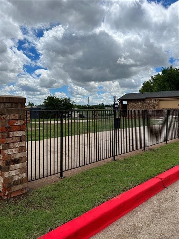 view of gate with a lawn