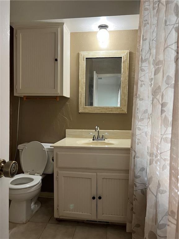 bathroom featuring tile patterned floors, vanity, and toilet