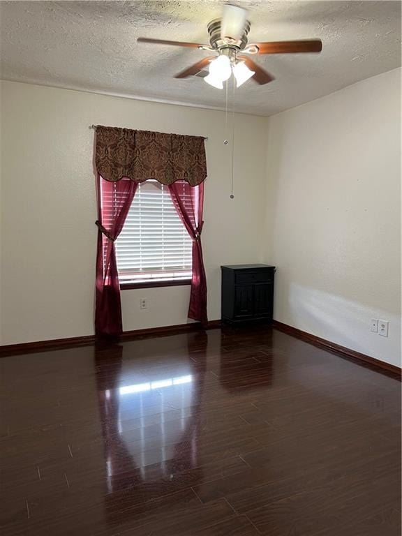 spare room with ceiling fan, dark hardwood / wood-style flooring, and a textured ceiling