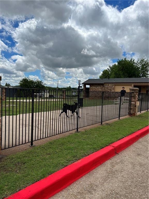 view of gate with a lawn