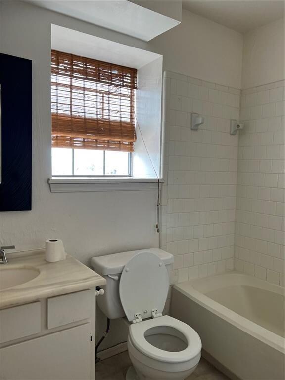 full bathroom with vanity, toilet, and tiled shower / bath combo