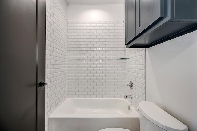 bathroom with toilet and tiled shower / bath