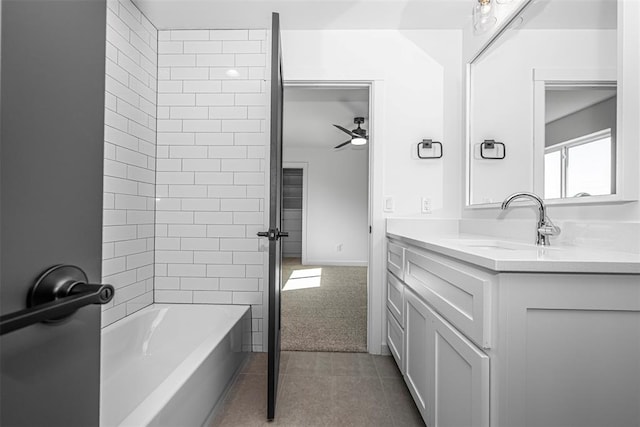 bathroom featuring tile patterned flooring, tiled shower / bath, vanity, and ceiling fan