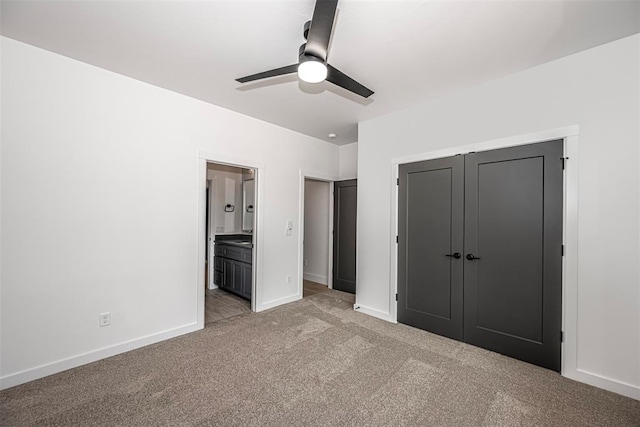 unfurnished bedroom featuring connected bathroom, light colored carpet, a closet, and ceiling fan