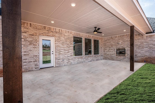 view of patio / terrace featuring ceiling fan and a large fireplace