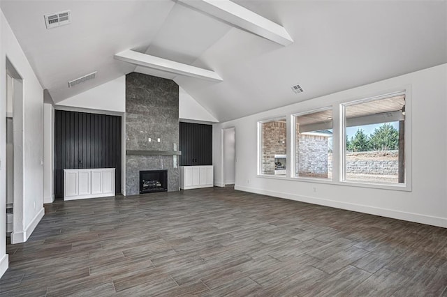 unfurnished living room with lofted ceiling with beams, a large fireplace, and dark hardwood / wood-style flooring