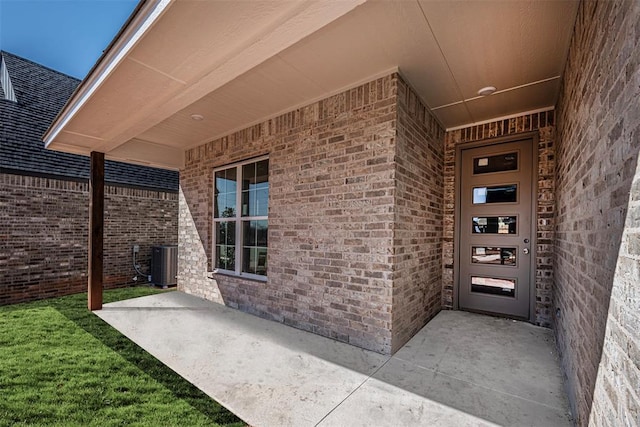 doorway to property with a patio area and central air condition unit