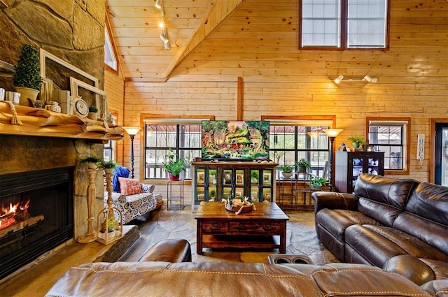 living room featuring beam ceiling, plenty of natural light, wooden walls, and wood ceiling