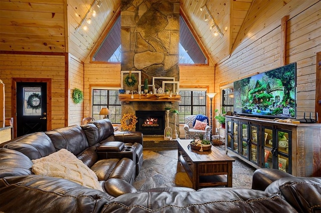 living room with a fireplace, high vaulted ceiling, wood ceiling, and wood walls